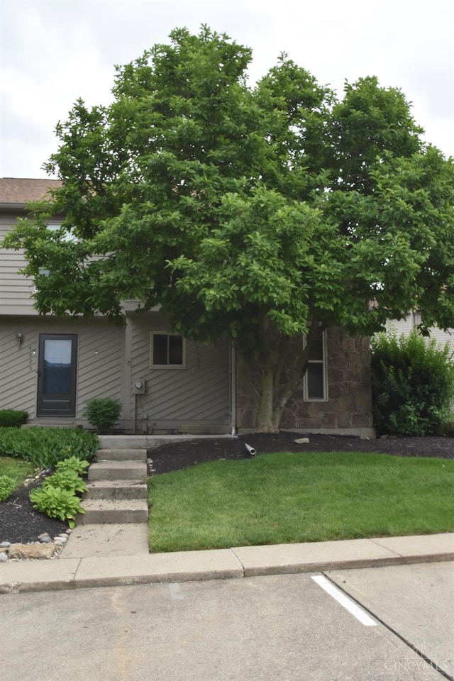 4923 Columbia Cir Unit 139, West Chester, OH 45011 - view of property hidden behind natural elements with uncovered parking, stone siding, and a front lawn