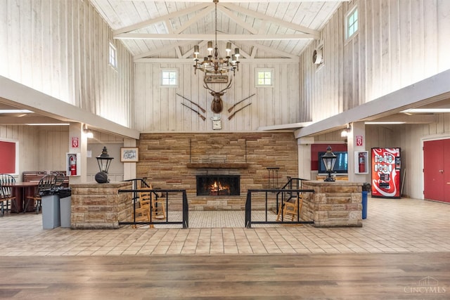 440 Waynoka Dr, Franklin Twp, OH 45171 - living room featuring high vaulted ceiling, a stone fireplace, wood walls, a chandelier, and wood finished floors
