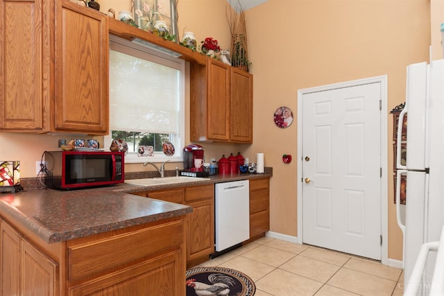 440 Waynoka Dr, Franklin Twp, OH 45171 - kitchen with white appliances, light tile patterned flooring, dark countertops, a towering ceiling, and brown cabinetry