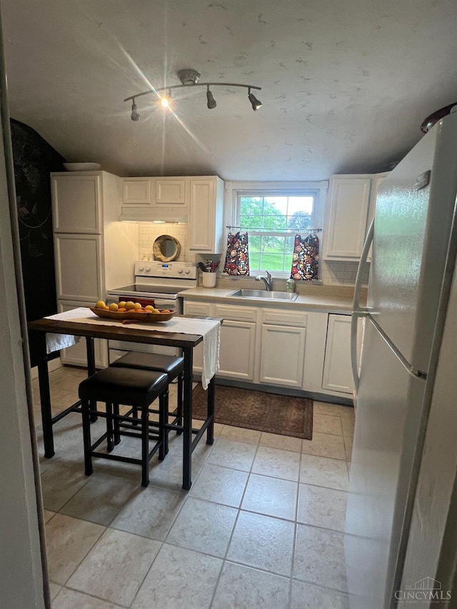 316 W S St, Hillsboro, OH 45133 - kitchen with white appliances, white cabinetry, light countertops, and under cabinet range hood