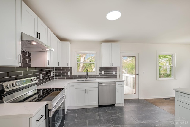 1407 Southwind Dr, Mason, OH 45040 - kitchen featuring appliances with stainless steel finishes, under cabinet range hood, decorative backsplash, light countertops, and white cabinets