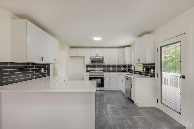 1407 Southwind Dr, Mason, OH 45040 - kitchen featuring appliances with stainless steel finishes, a peninsula, tasteful backsplash, dark marble finish floors, and white cabinetry