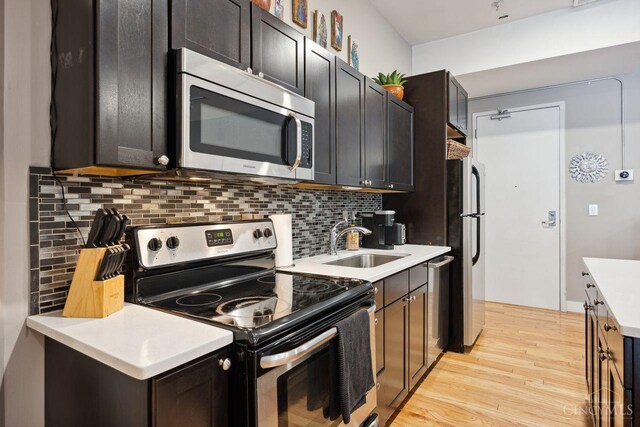 1150 Vine St Unit 15, Cincinnati, OH 45202 - kitchen with appliances with stainless steel finishes, light wood finished floors, backsplash, and light countertops