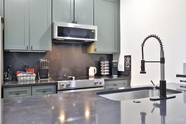 1407 Vine St Unit 203, Cincinnati, OH 45202 - kitchen with stainless steel appliances, tasteful backsplash, and dark stone countertops