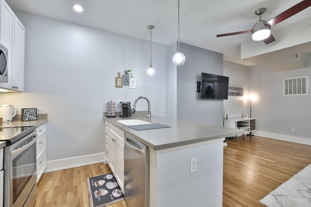 1407 Vine St Unit 303, Cincinnati, OH 45202 - kitchen featuring stainless steel appliances, a peninsula, ceiling fan, white cabinetry, and light wood-style flooring