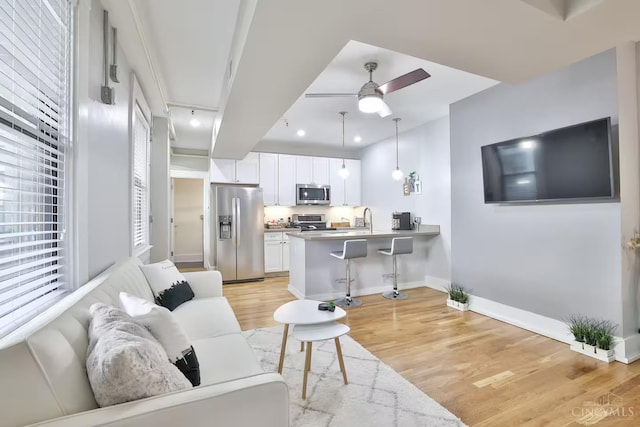 1407 Vine St Unit 303, Cincinnati, OH 45202 - living area featuring light wood-style floors, ceiling fan, and recessed lighting