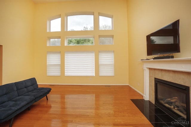 3779 Windyhollow Way, Mason, OH 45040 - living area with wood finished floors, a tiled fireplace, and a towering ceiling