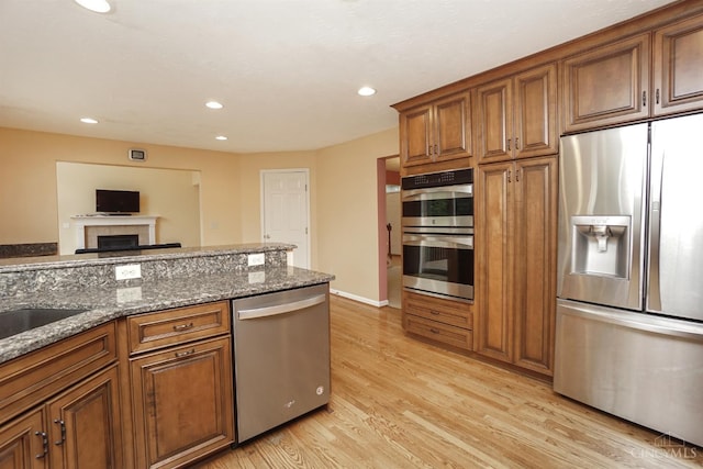 3779 Windyhollow Way, Mason, OH 45040 - kitchen with appliances with stainless steel finishes, brown cabinets, light wood finished floors, recessed lighting, and stone countertops