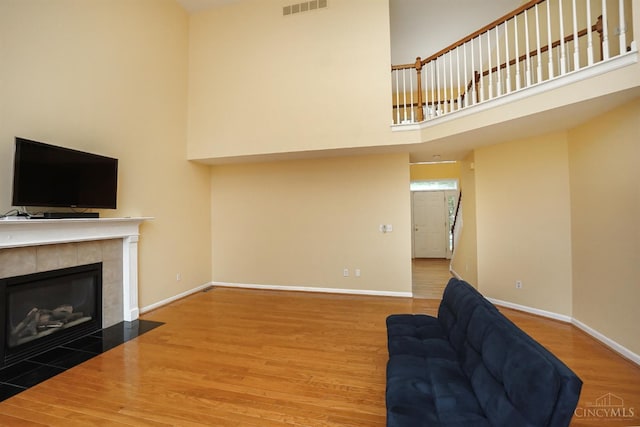 3779 Windyhollow Way, Mason, OH 45040 - unfurnished living room with a high ceiling, wood finished floors, and a tiled fireplace