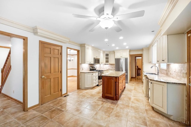 3057 Fox Den Ln, Anderson Twp, OH 45244 - kitchen featuring stainless steel appliances, ceiling fan, light stone counters, tasteful backsplash, and a kitchen island