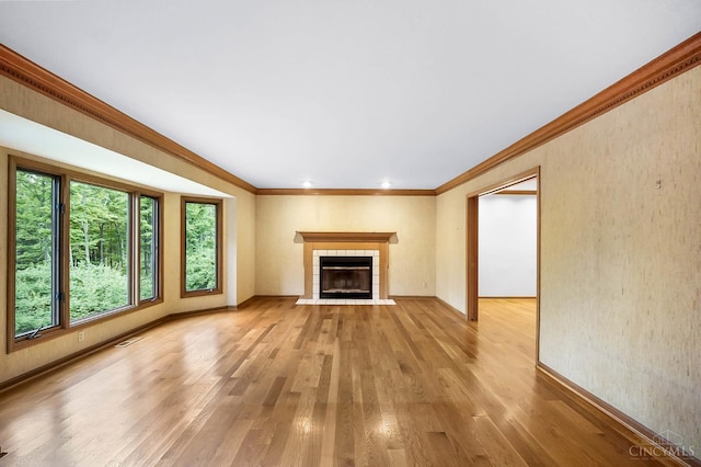 3057 Fox Den Ln, Anderson Twp, OH 45244 - unfurnished living room with light wood-type flooring, a tiled fireplace, ornamental molding, and recessed lighting