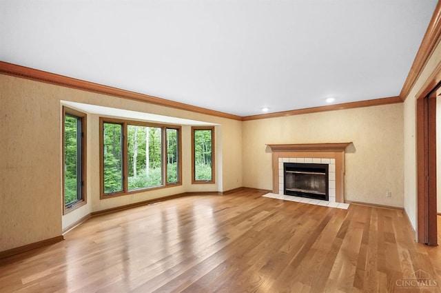 3057 Fox Den Ln, Anderson Twp, OH 45244 - unfurnished living room featuring plenty of natural light, ornamental molding, wood finished floors, and a tiled fireplace
