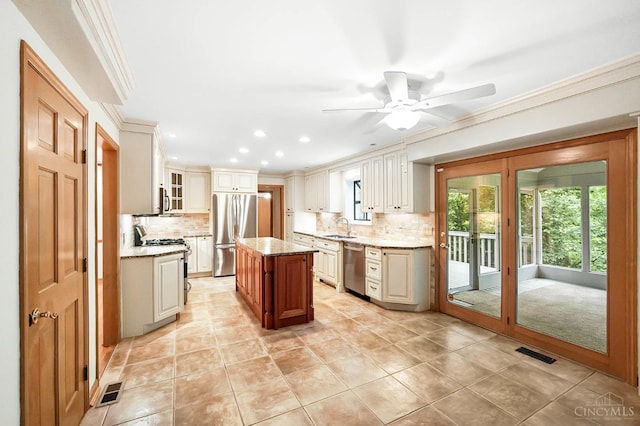 3057 Fox Den Ln, Anderson Twp, OH 45244 - kitchen with stainless steel appliances, backsplash, healthy amount of natural light, a ceiling fan, and crown molding