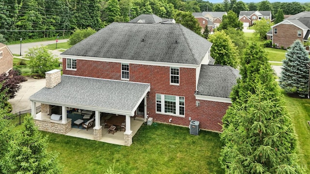 10285 Plantation Pointe Dr, Symmes Twp, OH 45140 - back of property featuring a shingled roof, a lawn, a patio, brick siding, and a chimney