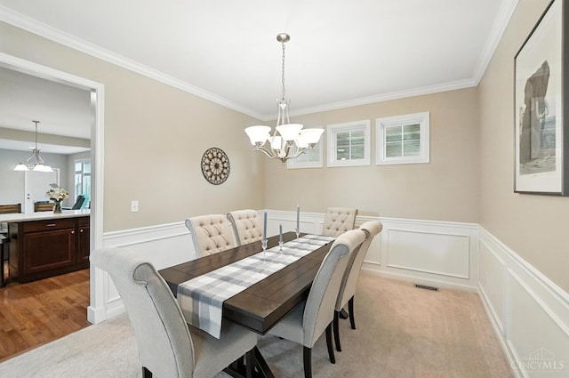 10285 Plantation Pointe Dr, Symmes Twp, OH 45140 - dining room featuring a chandelier, ornamental molding, light carpet, wainscoting, and a decorative wall