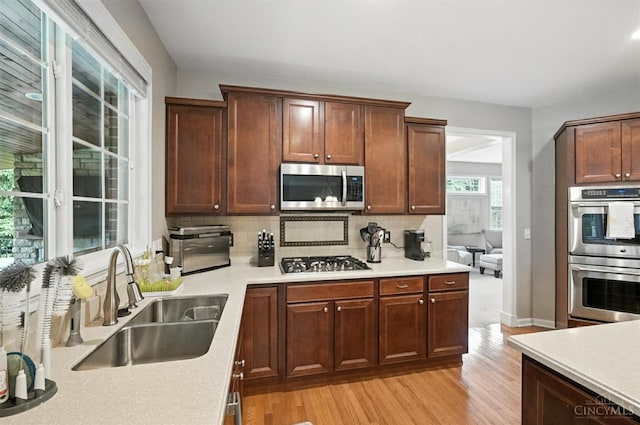 10285 Plantation Pointe Dr, Symmes Twp, OH 45140 - kitchen featuring stainless steel appliances, light wood-type flooring, decorative backsplash, and light countertops