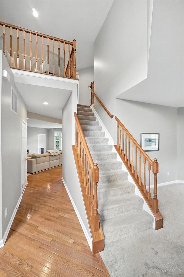 10285 Plantation Pointe Dr, Symmes Twp, OH 45140 - stairway with wood finished floors, recessed lighting, and a towering ceiling