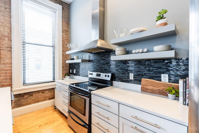 1201 Vine St Unit C, Cincinnati, OH 45202 - kitchen featuring open shelves, stainless steel range with electric stovetop, wall chimney exhaust hood, healthy amount of natural light, and brick wall