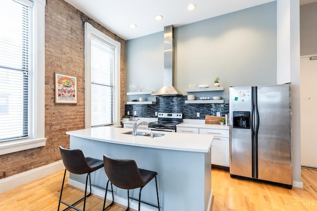 1201 Vine St Unit C, Cincinnati, OH 45202 - kitchen featuring stainless steel appliances, brick wall, light wood-style floors, white cabinets, and a kitchen bar