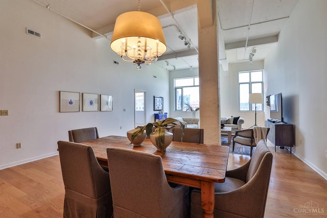 400 Pike St Unit 921, Cincinnati, OH 45202 - dining area with rail lighting, light wood finished floors, and a chandelier