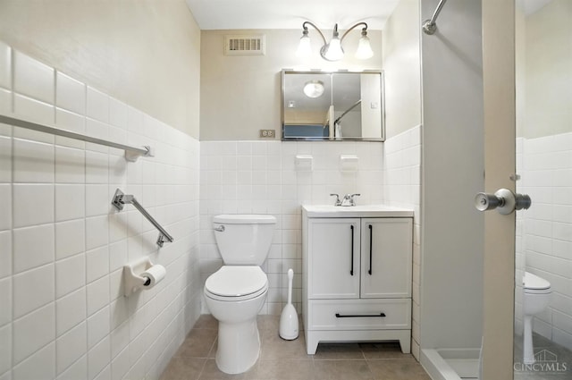2401 Ingleside Ave Unit 8D, Cincinnati, OH 45206 - full bathroom with tile walls, tile patterned floors, vanity, a stall shower, and a wainscoted wall