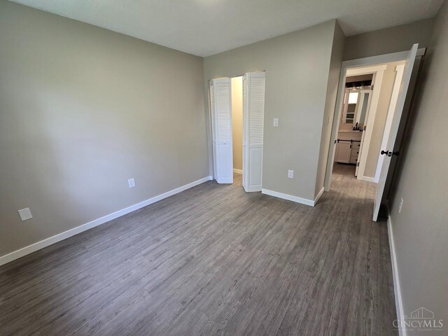 423 Howard St, Wilmington, OH 45177 - unfurnished bedroom featuring dark wood-style flooring and baseboards
