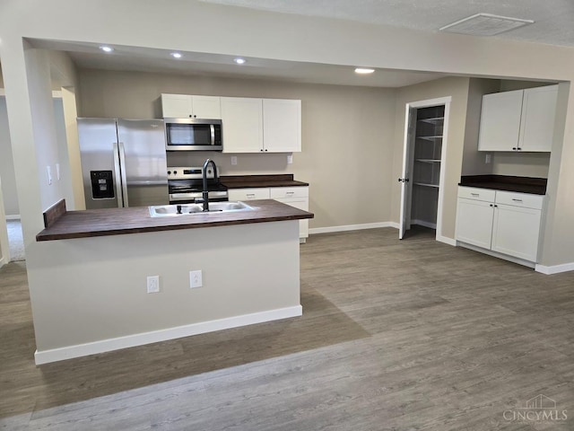 423 Howard St, Wilmington, OH 45177 - kitchen featuring appliances with stainless steel finishes, wood finished floors, white cabinetry, recessed lighting, and butcher block countertops