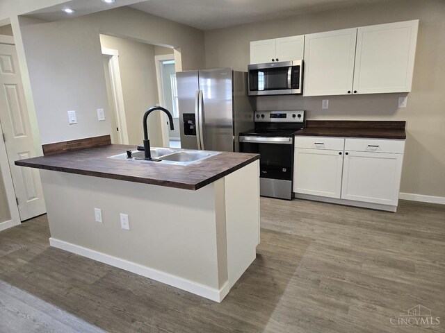 423 Howard St, Wilmington, OH 45177 - kitchen with stainless steel appliances, butcher block counters, wood finished floors, and white cabinets