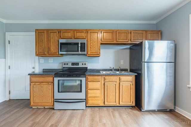2456 Wilbraham Rd, Middletown, OH 45042 - kitchen featuring stainless steel appliances, light wood-style flooring, dark countertops, ornamental molding, and brown cabinetry