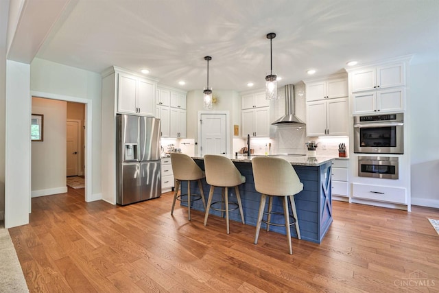 1439 Legacy Ct, Troy, OH 45373 - kitchen with stainless steel appliances, wall chimney exhaust hood, white cabinetry, and recessed lighting