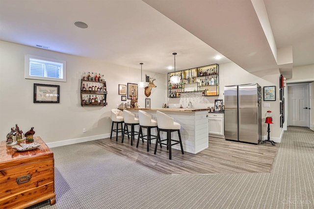 1439 Legacy Ct, Troy, OH 45373 - kitchen featuring freestanding refrigerator, light carpet, a breakfast bar area, and open shelves