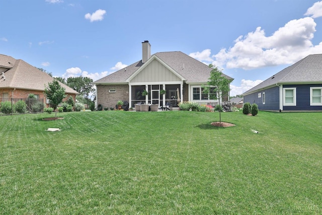 1439 Legacy Ct, Troy, OH 45373 - rear view of property with a lawn, a chimney, a sunroom, and board and batten siding
