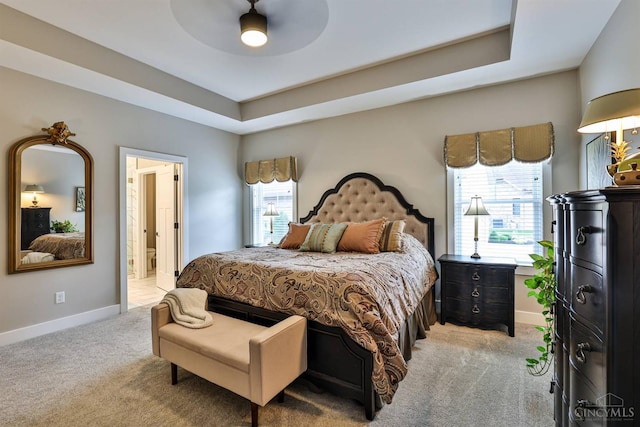 1439 Legacy Ct, Troy, OH 45373 - bedroom with light colored carpet, ensuite bath, a raised ceiling, and ceiling fan