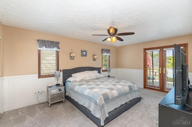 501 Tara Oaks Dr, Middletown, OH 45042 - bedroom with a wainscoted wall, access to exterior, light colored carpet, multiple windows, and a textured ceiling