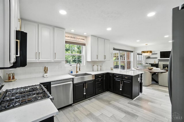 4870 Highland Oaks Dr, Green Twp, OH 45248 - kitchen featuring stainless steel dishwasher, white cabinetry, light countertops, decorative backsplash, and recessed lighting