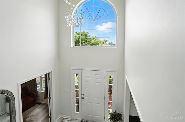 4870 Highland Oaks Dr, Green Twp, OH 45248 - foyer entrance featuring a high ceiling, healthy amount of natural light, wood finished floors, and a chandelier