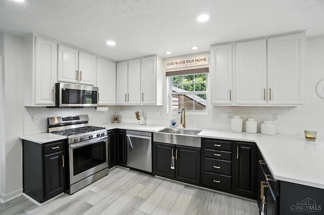 4870 Highland Oaks Dr, Green Twp, OH 45248 - kitchen with appliances with stainless steel finishes, dark cabinetry, white cabinets, and recessed lighting
