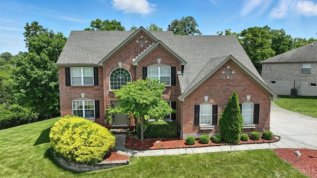 4870 Highland Oaks Dr, Green Twp, OH 45248 - traditional-style home with brick siding, a front lawn, a shingled roof, and concrete driveway