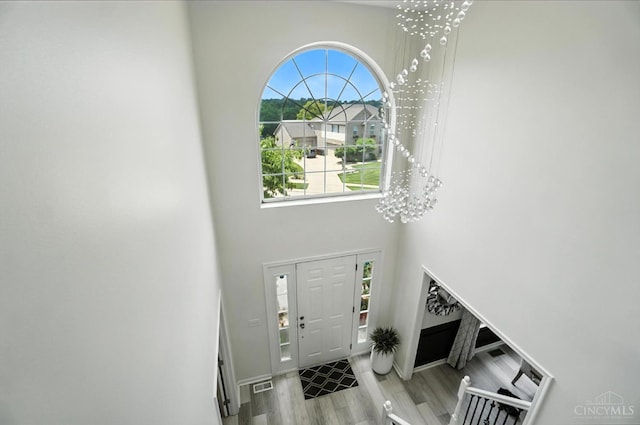 4870 Highland Oaks Dr, Green Twp, OH 45248 - foyer entrance with wood finished floors, a towering ceiling, and a chandelier