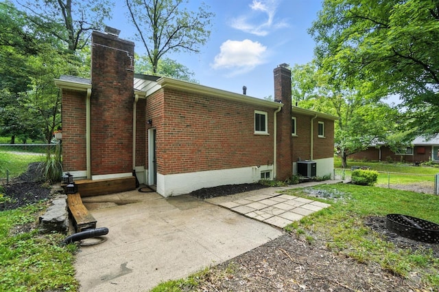 2000 Neeb Rd, Green Twp, OH 45233 - rear view of house featuring a chimney, brick siding, and a patio