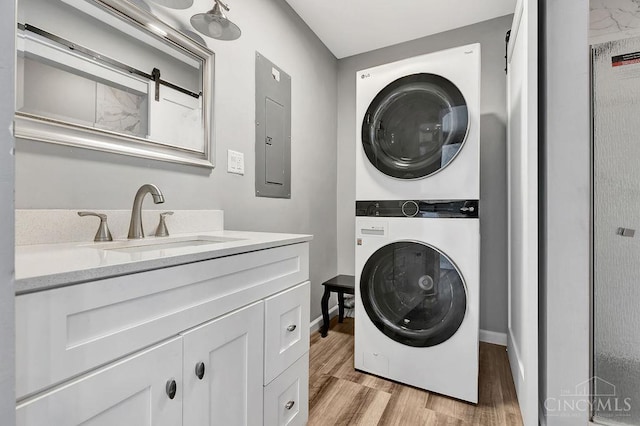 711 Van Roberts Pl, Wyoming, OH 45215 - laundry room with estacked washer and dryer, electric panel, and light wood-style flooring