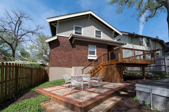 2851 Pine Grove Ave, Cincinnati, OH 45208 - back of house featuring stucco siding, a fenced backyard, a deck, and stairway