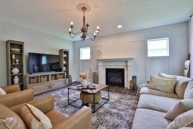 6352 Copperleaf Ln, Miami Twp, OH 45140 - living area with wood finished floors, a chandelier, healthy amount of natural light, a glass covered fireplace, and recessed lighting