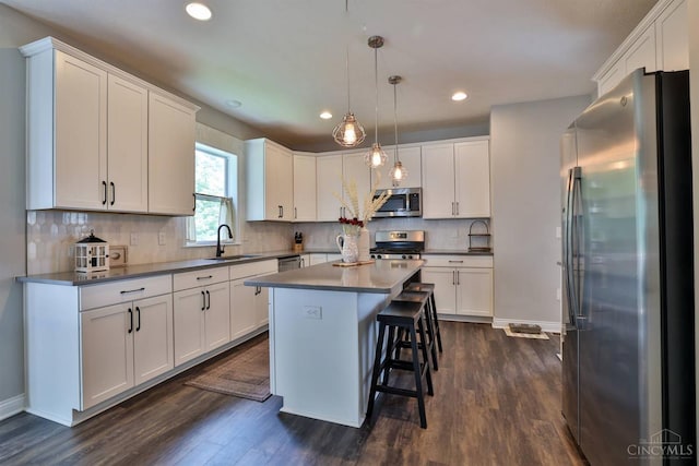 6352 Copperleaf Ln, Miami Twp, OH 45140 - kitchen with appliances with stainless steel finishes, recessed lighting, dark wood-type flooring, white cabinets, and a kitchen island