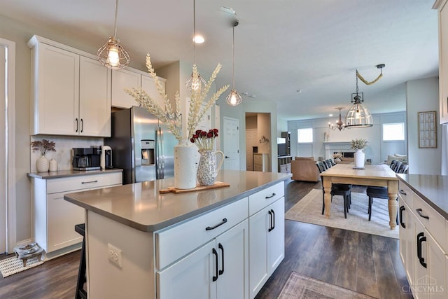 6352 Copperleaf Ln, Miami Twp, OH 45140 - kitchen featuring stainless steel fridge with ice dispenser, dark wood-style flooring, a center island, white cabinetry, and decorative light fixtures