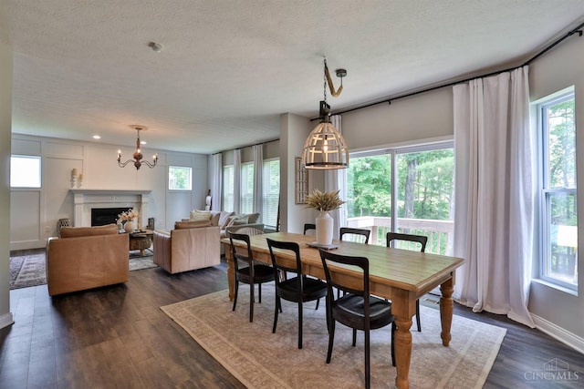 6352 Copperleaf Ln, Miami Twp, OH 45140 - dining space featuring a textured ceiling, a chandelier, dark wood finished floors, and a fireplace