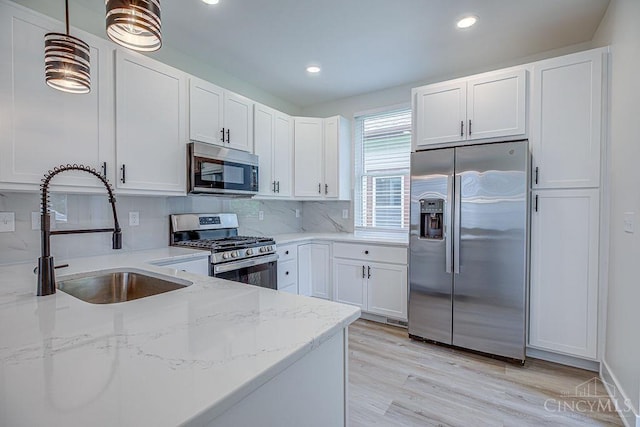 3104 Celeron Ave, Cincinnati, OH 45209 - kitchen featuring appliances with stainless steel finishes, light stone countertops, white cabinetry, tasteful backsplash, and light wood-style floors