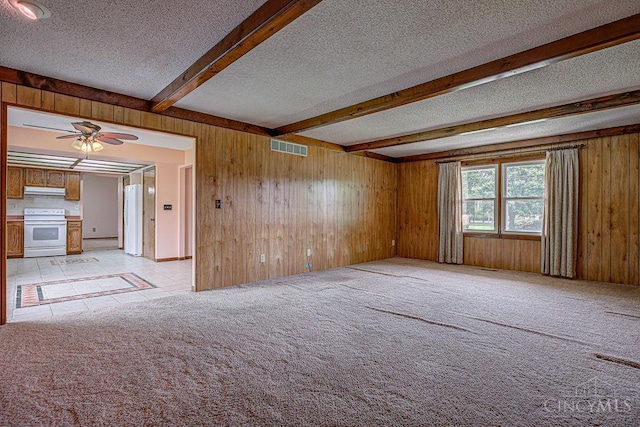 2974 Acer Ct, Ross Twp, OH 45013 - empty room featuring a textured ceiling, beam ceiling, a ceiling fan, wooden walls, and light carpet