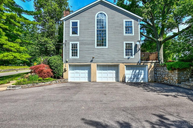 254 Compton Rd, Wyoming, OH 45215 - view of home's exterior with a chimney, asphalt driveway, and a garage