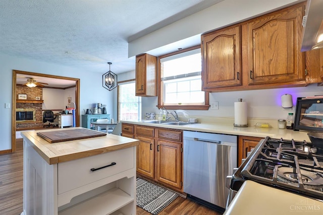 2487 Haddock Dr, Lawrenceburg, IN 47025 - kitchen with dishwasher, dark wood-type flooring, brown cabinets, gas range, and a textured ceiling